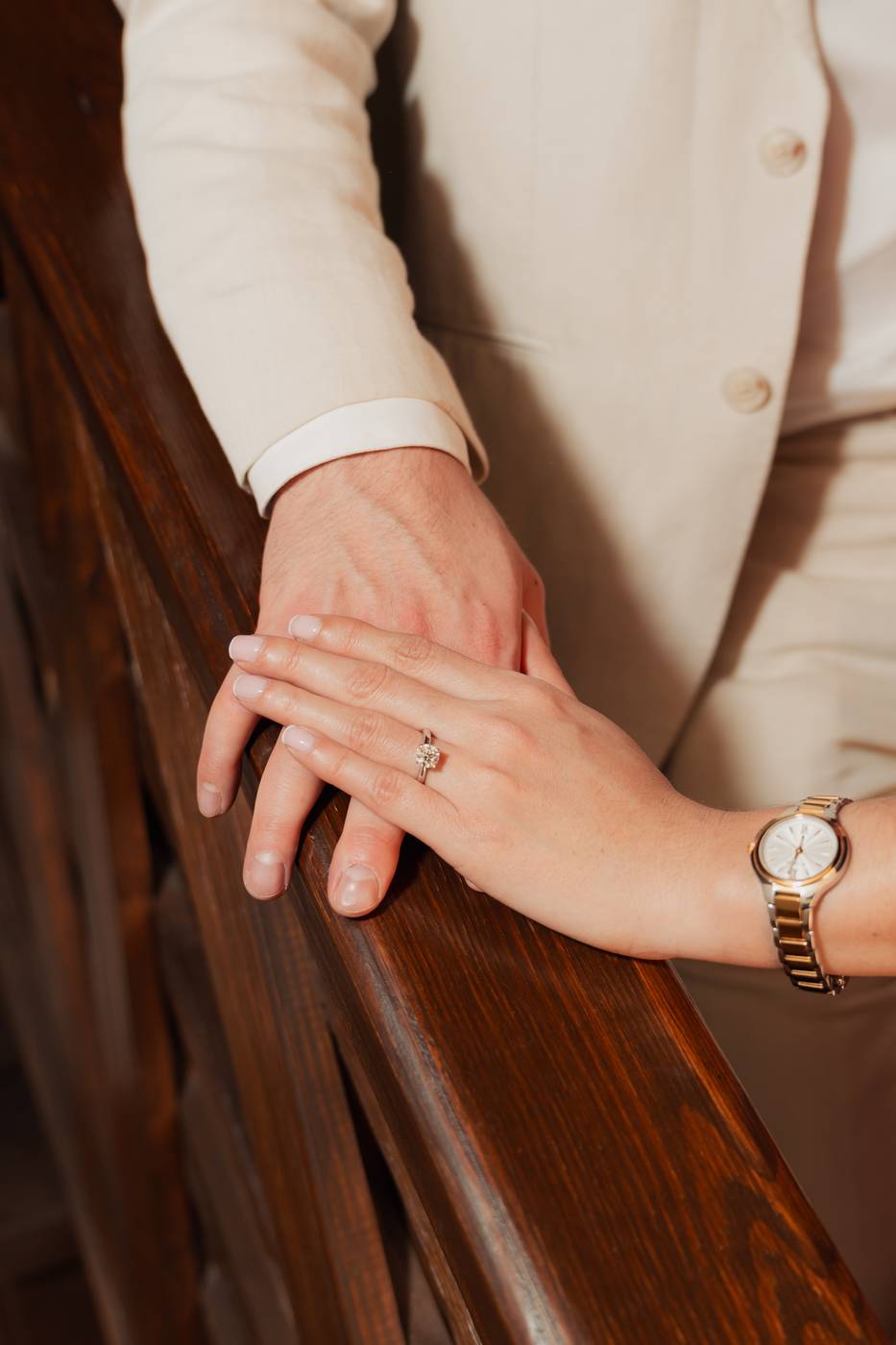 Mano de Gabriela con su anillo de compromiso sobre la de Eduardo